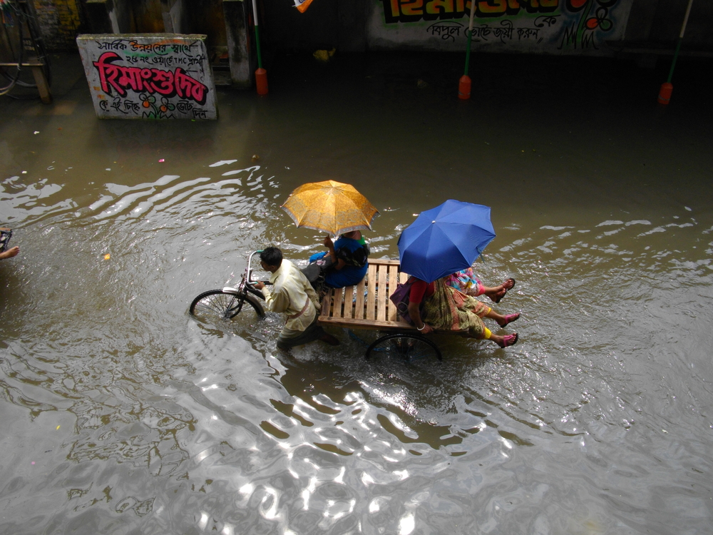 AGARPAR, KOLKATA, INDIA - OCTOBER 15 : Unidentified people wade through water logged street due rain as tropical storm Phailin made landfall in India on October 15, 2013 in Agarpara, Kolkata, India.